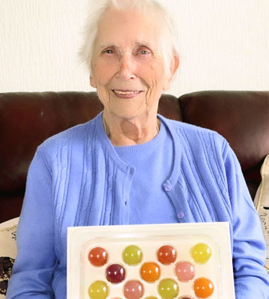Elderly Woman With A Pack Of Jelly Drops Sweets